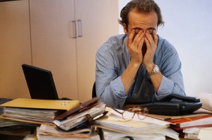 Man covering his face in office